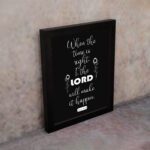 Infidu wall art displaying When the time is right, I, the LORD will make it happen with emphasis on "LORD" in large text. displayed on the wall in a black frame