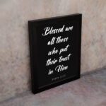 Blessed Are All Those Who Put Their Trust In Him Psalm 2:12 white text on a black background displayed on the wall in a black frame - Christian wall art for home decor