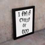 I Am a Child of God Bible wall art with bold black text on a white background, framed by a subtle black border. Wall Art displayed on the wall in a black frame