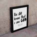 Be Still and Know That I Am God Psalm 46:10 Bible Verse Wall Art with black text on a white background Wall Art displayed on the wall in a black frame