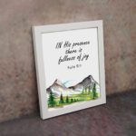 In His Presence There Is Fullness of Joy - Psalm 16:11 Bible Verse Wall Art with Mountains and Trees on White Background Wall Art displayed on the wall in a white frame