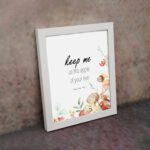 Keep Me As The Apple Of Your Eye Psalm 17:8 Bible Verse Wall Art with watercolor fruits and flowers. Wall Art displayed on the wall in white frame