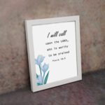 I Will Call Upon The Lord Psalm 18:3 Bible Verse Wall Art with black text on a light background and a soft blue flower in the bottom left corner. Wall Art displayed on the wall in a white frame