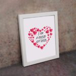 Infidu I Am A Child Of God Bible Wall Art with pink hearts and mixed cursive and print text on a light pink background Wall Art displayed on the wall in a white frame