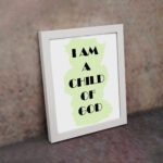 Infidu I Am A Child Of God Bible Wall Art with light green shape and black text on a white background Wall Art displayed on the wall in a white frame