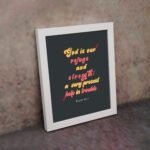 Psalm 46:1 Bible Wall Art with bold, colorful text on a deep black background. Wall Art displayed on the wall in a white frame