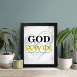 God Will Provide Christian wall art with bold black 'God,' gray and yellow text, and a heart-like light gray background. Wall Art displayed on the table in a black frame