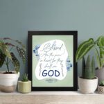 Infidu Matthew 5:8 Christian wall art with silver and dark blue text on a pale green background, featuring 'GOD' in a white oval and blue floral designs. Wall Art displayed on the wall in a black frame