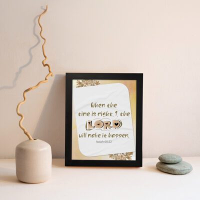 Christian wall art featuring Isaiah 60:22 with elegant text and a peach background, highlighting 'The Lord will make it happen. Wall Art displayed on the wall in a black frame