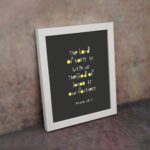 Psalm 46:7 Bible Verse Christian Wall Art - The Lord of Hosts is With Us, Minimalistic Design with Gold Accents. displayed on the wall in a white frame