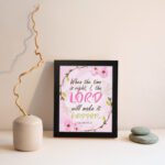 Isaiah 60:22 Christian Wall Art - When The Time Is Right, I, The Lord Will Make It Happen with floral design in pink and green. Wall Art displayed on the wall in a black frame