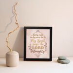 Zechariah 4:6 Christian wall art featuring Not By Might Nor By Power in gold script on a light peach background with floral accents. Wall Art kept on the wall in a black frame