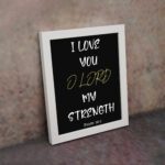 Psalm 18:1 Bible verse wall art with I LOVE YOU in white and O LORD in yellow on a black background. Christian decor by Infidu. Wall Art displayed on the wall in a white frame