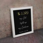 Psalm 18:28 Bible verse wall art with The LORD in yellow on a black background. Christian decor by Infidu. Wall Art displayed on the wall in a white frame