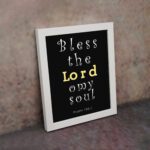 Infidu Bless The Lord O My Soul Psalm 103:1 Bible Wall Art with Black Background and Yellow, White Font white frame on the wall