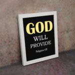 Christian wall art with Philippians 4:19 verse on black background, yellow and white font white frame on the wall