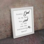 Bible verse wall art with Psalm 54:4, featuring black text on a white background. God and the Lord are highlighted in cursive font. displayed on the wall in a white frame