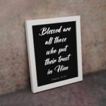 Blessed Are All Those Who Put Their Trust In Him Psalm 2:12 white text on a black background displayed on the wall in a white frame - Christian wall art for home decor