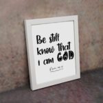 Be Still and Know That I Am God Psalm 46:10 Bible Verse Wall Art with black text on a white background Wall Art displayed on the wall in a white frame