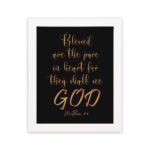 Infidu wall art with the text Blessed are the pure in heart, for they shall see God in gold font on a black background. hung on the wall in a white frame