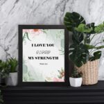 Infidu I Love You O Lord My Strength Psalm 18:1 Bible Wall Art with a green floral background and pink flowers Wall Art displayed on the table in a black frame