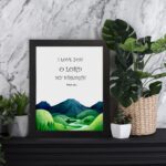 Infidu Psalm 18:1 Bible wall art with a serene mountain and river illustration, black text on a white background. Wall Art displayed on the table in a black frame