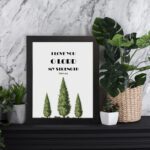 Psalm 18:1 Bible Wall Art with bold text and green trees on a white background. Wall Art displayed on the table in a black frame