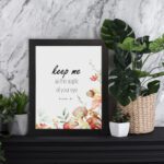 Keep Me As The Apple Of Your Eye Psalm 17:8 Bible Verse Wall Art with watercolor fruits and flowers. Wall Art displayed on the wall in white frame