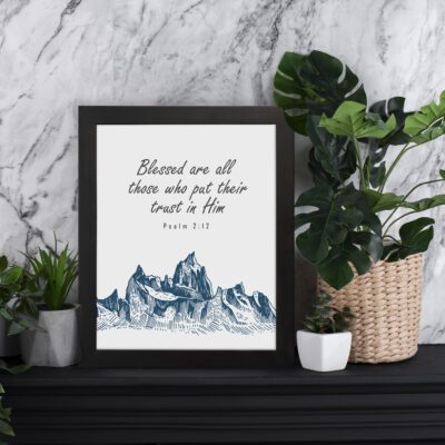 Psalm 2:12 Bible Verse Wall Art with deep blue mountain range design. Wall Art displayed on the table in a black frame