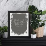 Bible wall art with Psalm 2:12 verse on a dark green background with textured brush-stroke border, featuring white text. Wall Art displayed on the table in black frame