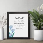 I Will Call Upon The Lord Psalm 18:3 Bible Verse Wall Art with black text on a light background and a soft blue flower in the bottom left corner. Wall Art displayed on the table in a black frame