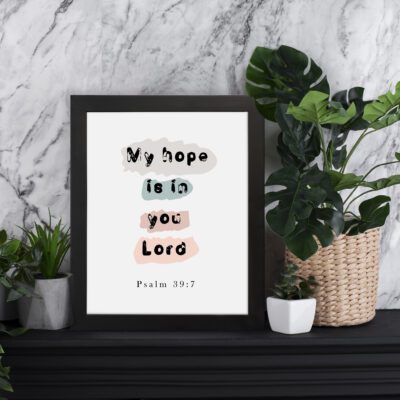 Colorful My Hope Is In You Lord Bible Verse Wall Art in soft pink, green, and blue on a white background Wall Art displayed on the table in a black frame