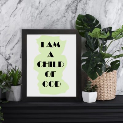 Infidu I Am A Child Of God Bible Wall Art with light green shape and black text on a white background Wall Art displayed on the table in a black frame