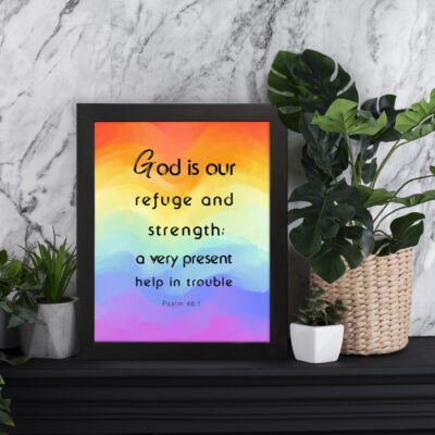 Psalm 46:1 Bible Wall Art with black vertical text on a vibrant rainbow gradient background. Wall Art displayed on the table in a black frame