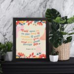 Psalm 50:15 Bible Verse Wall Art with colorful text, floral patterns, bird illustration, and beige background. Wall Art displayed on the table in a black frame