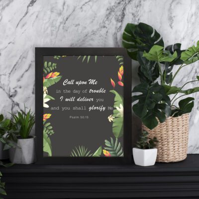 Psalm 50:15 Bible Verse Wall Art with white text, tropical leaves, and black background. Wall Art displayed on the table in a black frame