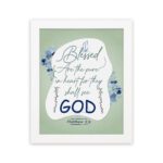 Infidu Matthew 5:8 Christian wall art with silver and dark blue text on a pale green background, featuring 'GOD' in a white oval and blue floral designs. Wall Art hung on the wall in a white frame