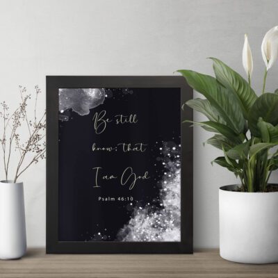 Be Still and Know That I Am God Psalm 46:10 Christian wall art with handwritten text on a navy blue background. wall art displayed on the wall in a black frame