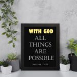 Matthew 19:26 Bible verse wall art with bold text, WITH GOD in yellow on a black background. Christian decor by Infidu. Wall Art displayed on the wall in a black frame