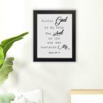 Bible verse wall art with Psalm 54:4, featuring black text on a white background. God and the Lord are highlighted in cursive font. hung on the floor in a black frame