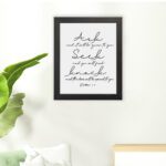 Matthew 7:7 Bible wall art in elegant cursive, highlighting Ask, Seek, and Knock on a white background. hung on the floor in a black frame