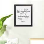 In His Presence There Is Fullness of Joy in a black script font with decorative branches and Psalm 16:11 on a white background - Christian wall art. hung on the floor in a black frame