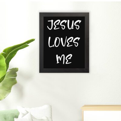 Jesus Loves Me Bible wall art with bold gold text and a decorative gold border on a black background. Wall Art hung on the floor in a black frame