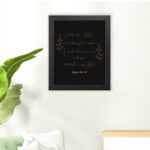 Infidu Call Upon Me In The Day Of Trouble Psalm 50:15 Bible Wall Art with gold text on a black background and subtle leaf illustrations. Wall Art hung on the floor in a black frame