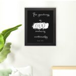 Infidu The Goodness of God Endures Continually Psalm 52:1 Bible Verse Wall Art with white text on black background. Wall Art hung on the floor in a black frame