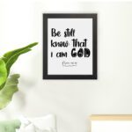 Be Still and Know That I Am God Psalm 46:10 Bible Verse Wall Art with black text on a white background Wall Art hung on the floor in a black frame