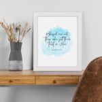 Serene Bible verse wall art with Psalm 2:12 and soft blue watercolor design, perfect for peaceful home decor. Wall Art displayed on the table in a white frame