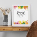 Vibrant Bible wall art with Psalm 2:12 verse and colorful paint splash in green, yellow, pink, and orange. Wall Art displayed on the table in a white frame