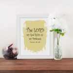 The Lord My God Lights Up My Darkness Psalm 18:28 Bible Verse Wall Art with decorative text on a light yellow paint stroke background. Wall Art displayed on the wall in a white frame