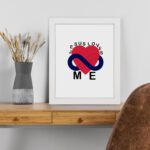 Infidu Jesus Loves Me Bible Wall Art with red heart and blue infinity symbol, with the text JESUS LOVES ME around the image Wall Art displayed on the table in white frame